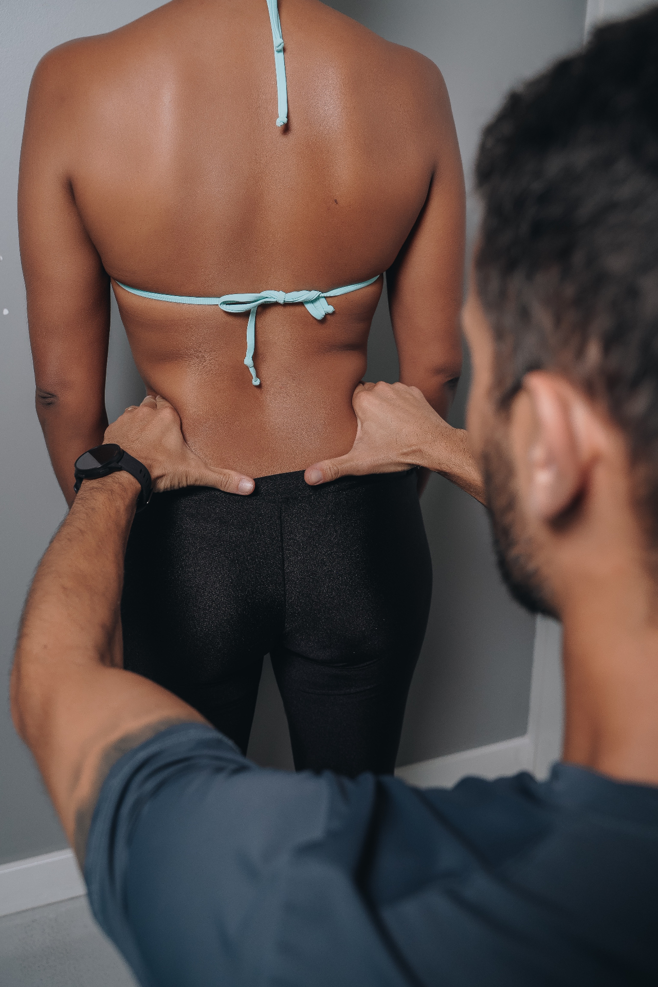 Profissional Fortius avaliando a mobilidade e postura de uma aluna durante atendimento individualizado.
